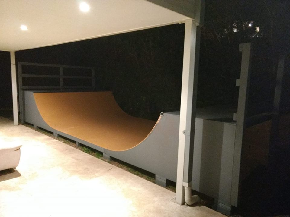 3.5ft high mini ramp (half-pipe skateboard) ramp, painted grey and orange off verandah at twilight