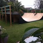 Skater on 4ft mini ramp (half pipe skateboard ramp) in garden